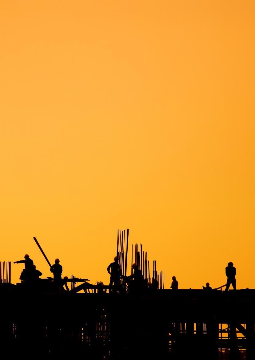 Silhouette of construction workers on site at sunset