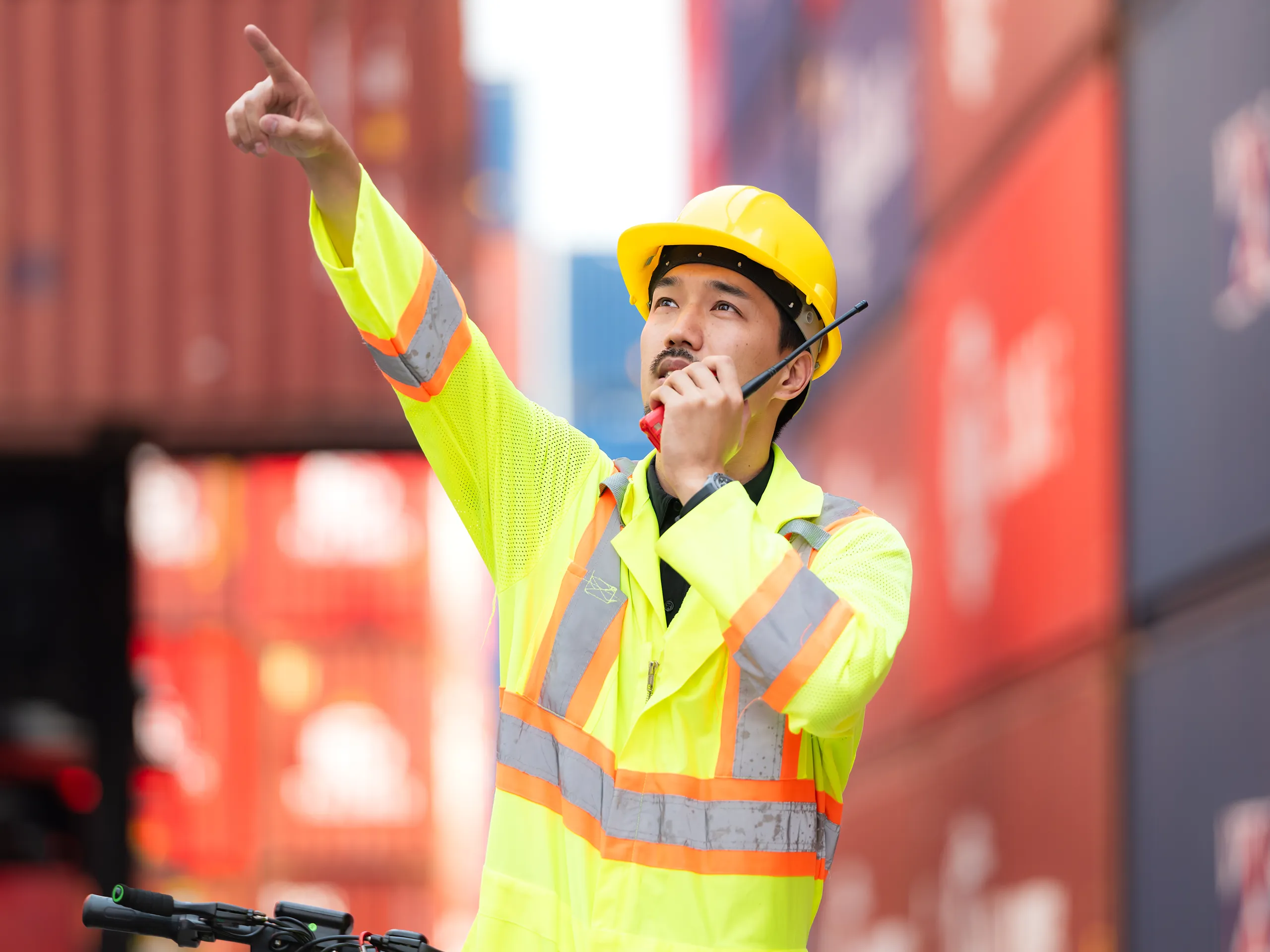 Banksman directing vehicle movement by radio at a container yard