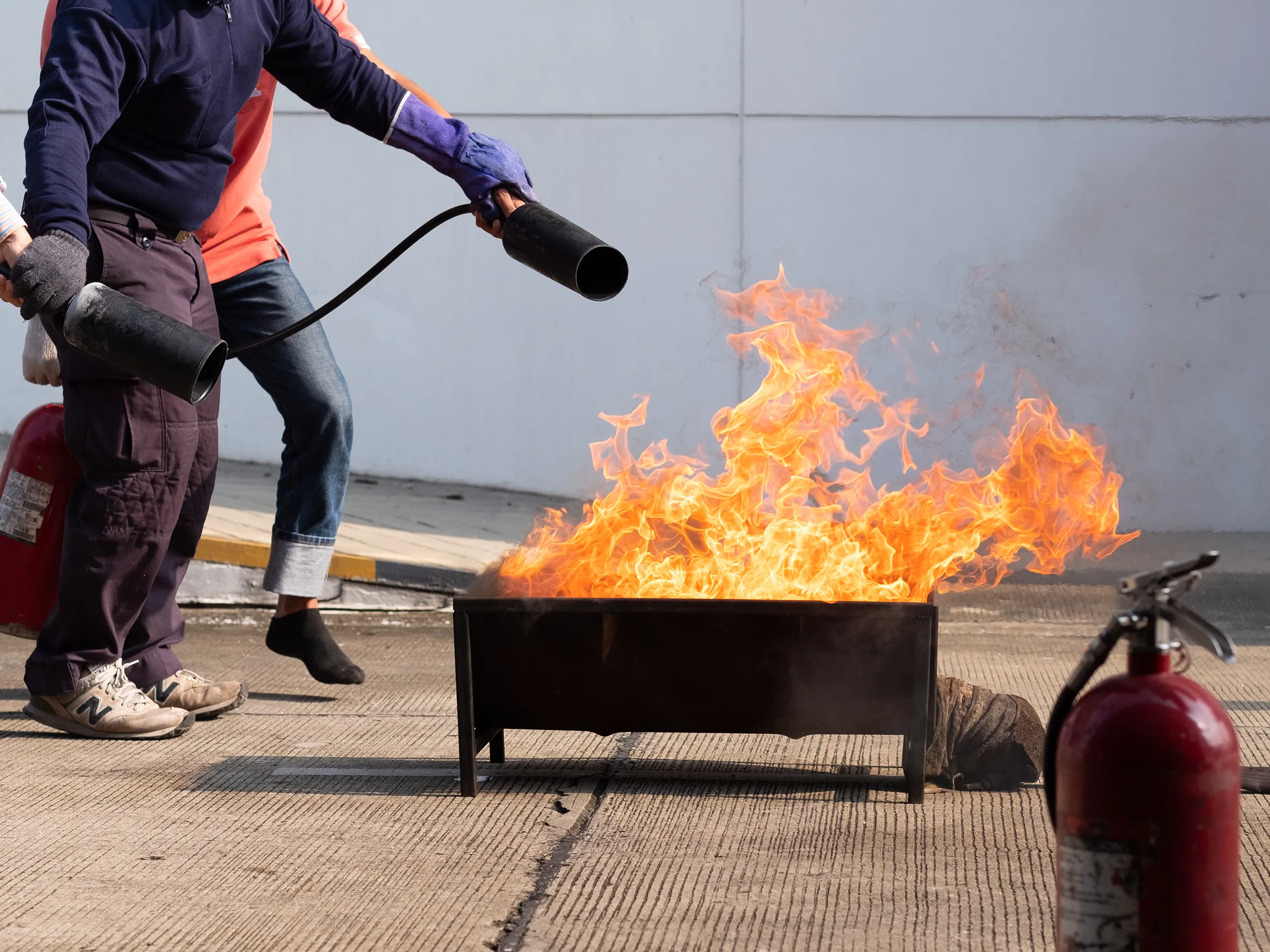 Trainees practising live fire extinguisher use during fire fighting training