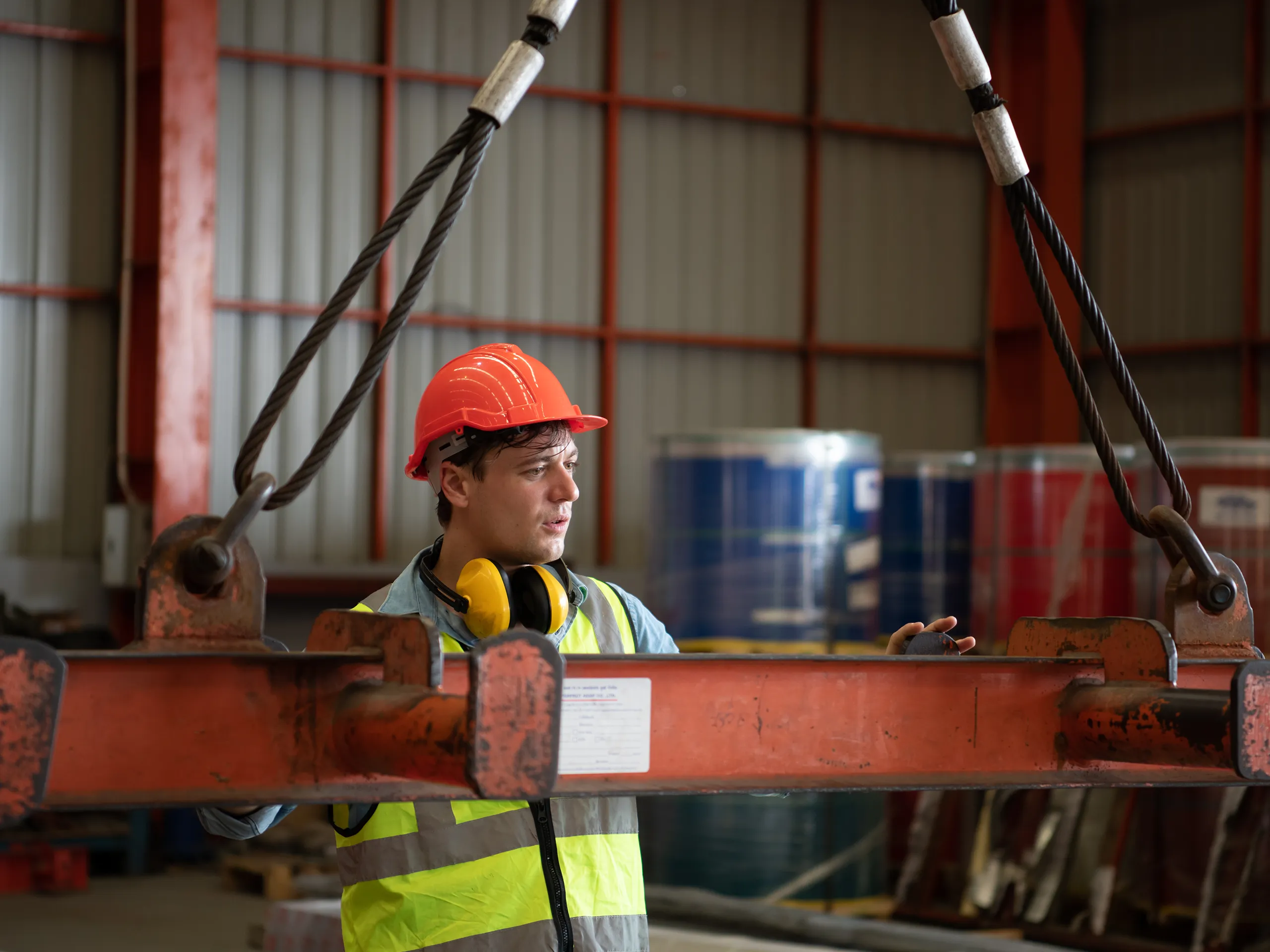 Worker guiding a lifting beam during a supervised lifting operation